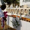 A member of the French aid group Action Contre La Faim places a wreath in front of the photographs of his 17 slain colleagues at their memorial in Batticaloa, Sri Lanka, August 11, 2006. REUTERS/Buddhika Weerasinghe (SRI LANKA)